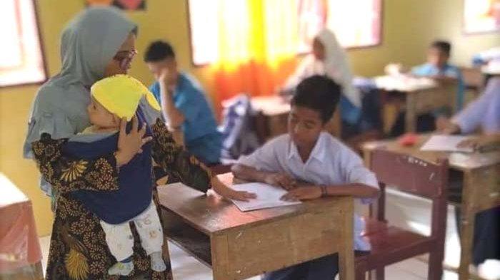 Viral! Guru Gendong Bayi Lewat Jalan Berlumpur Untuk Mengajar di Sekolah