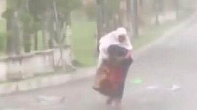 Terharu! Anak Gendong Ibunya Untuk Berteduh Saat Shalat Idul Fitri Diguyur Hujan